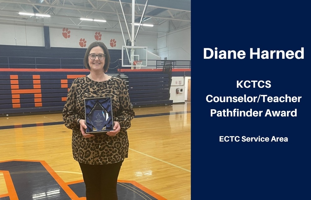 Diane Harned standing in GCHS gym holding KCTCS Pathfinder Award