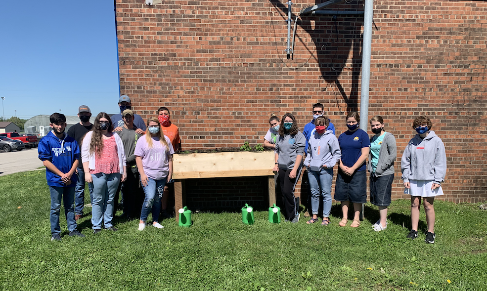 Ag students outside with raised herb garden bed