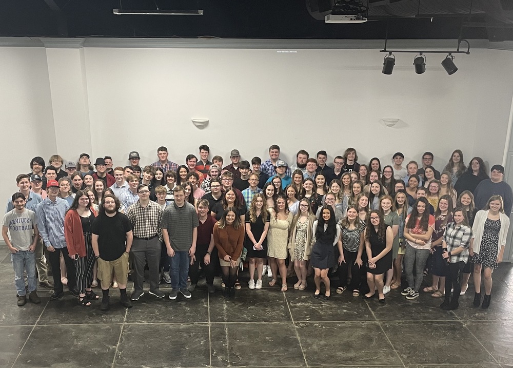 Very large group of male and female students who have earned industry certifications standing in front of a white wall at The Centre on Main