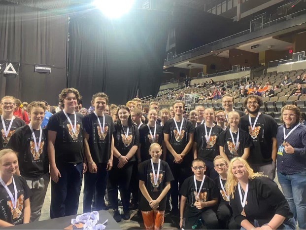 GCHS Percussion Members with medals on kneeling and standing in a gym