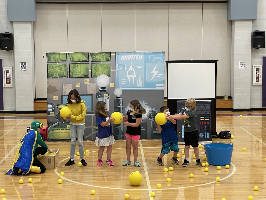 five children passing yellow balls to costumed character