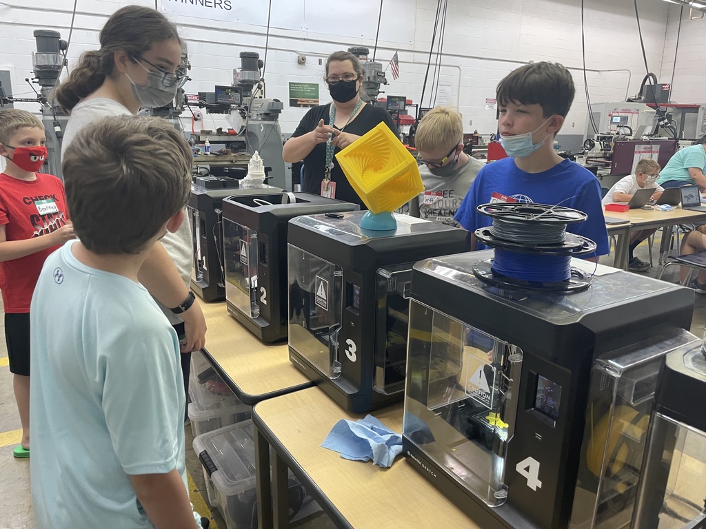 boys and two women looking at 3d printers