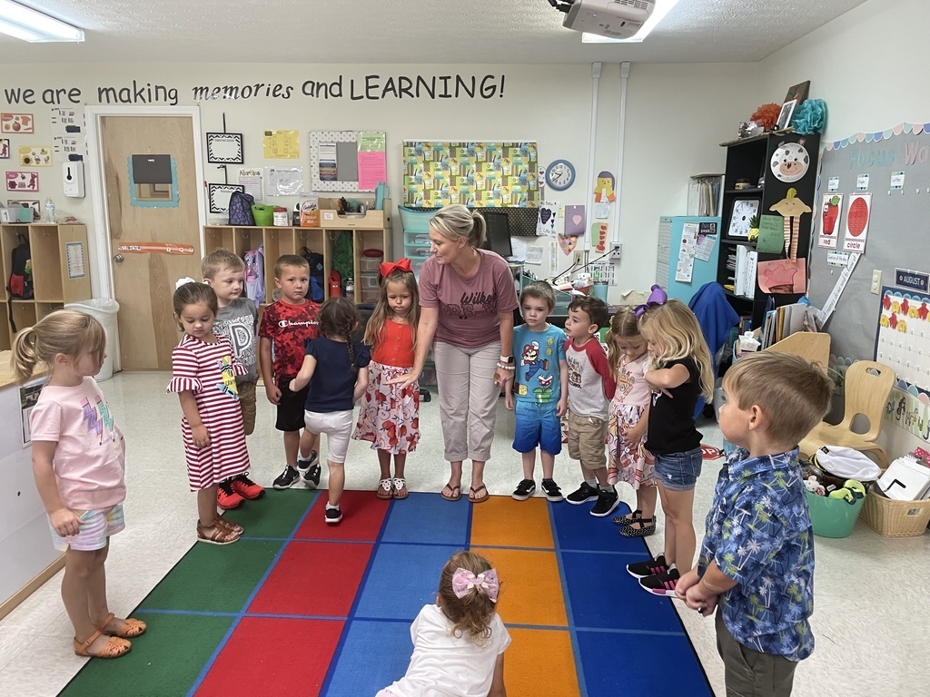 Small children standing around a teacher