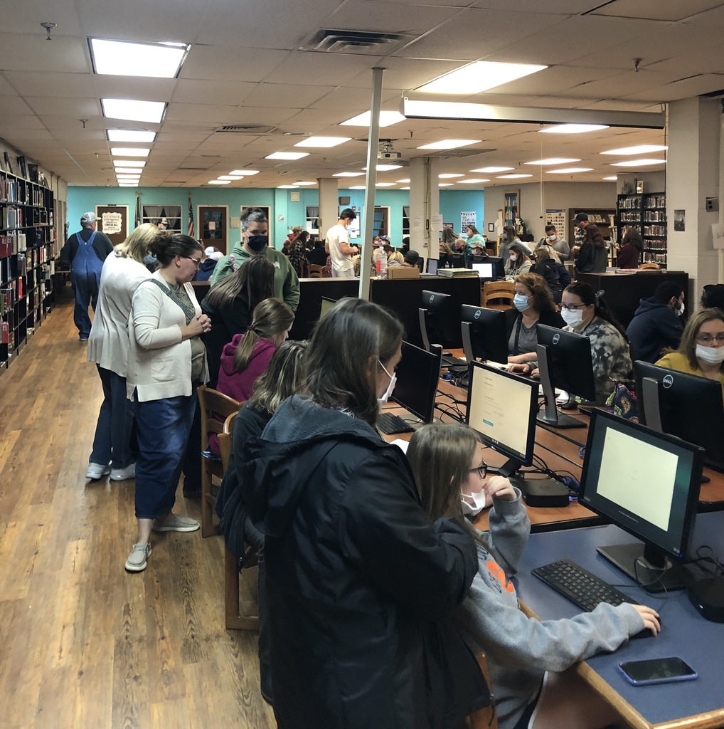 students and parents at computers in a  library