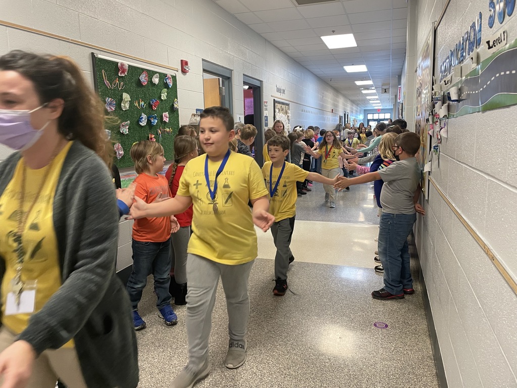 kids walking down a hallway high fiving other kids 