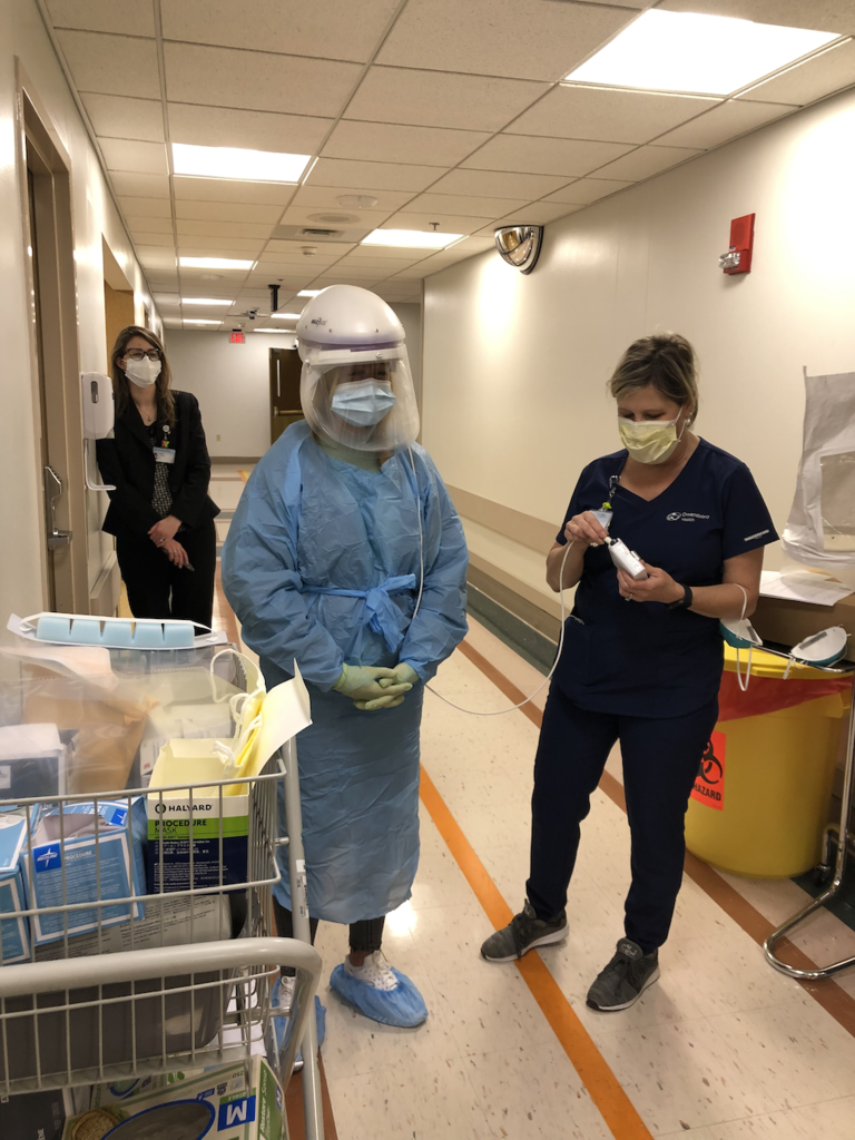 student in medical attire with a medical pro to right