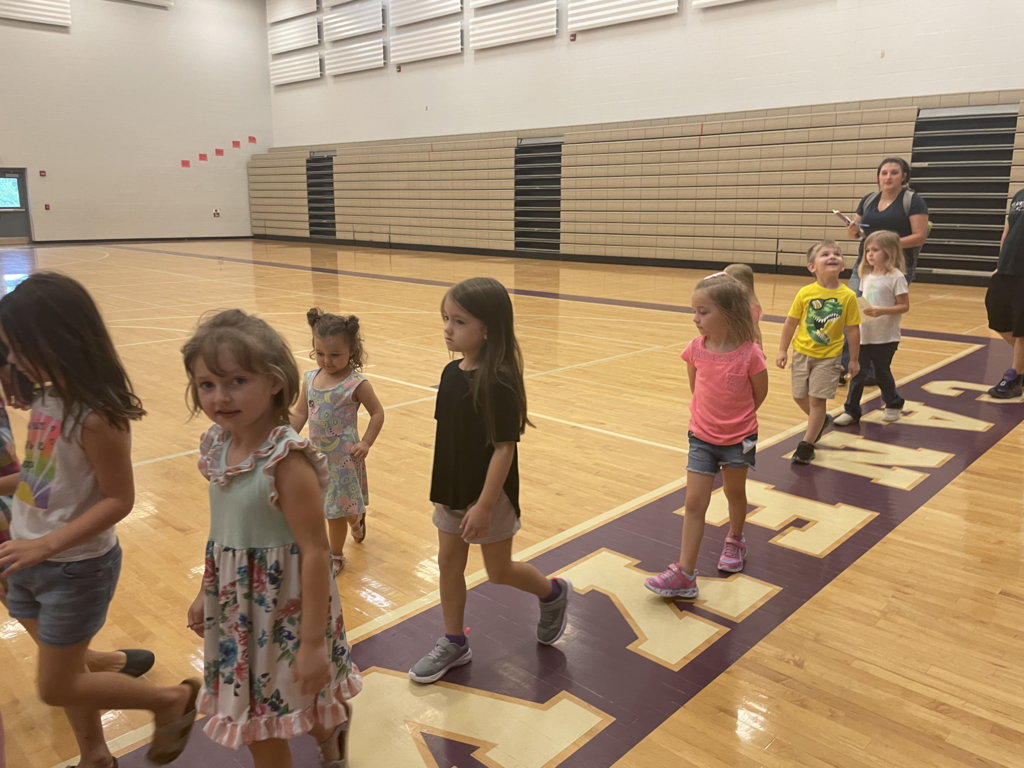 children walking in line through a gym