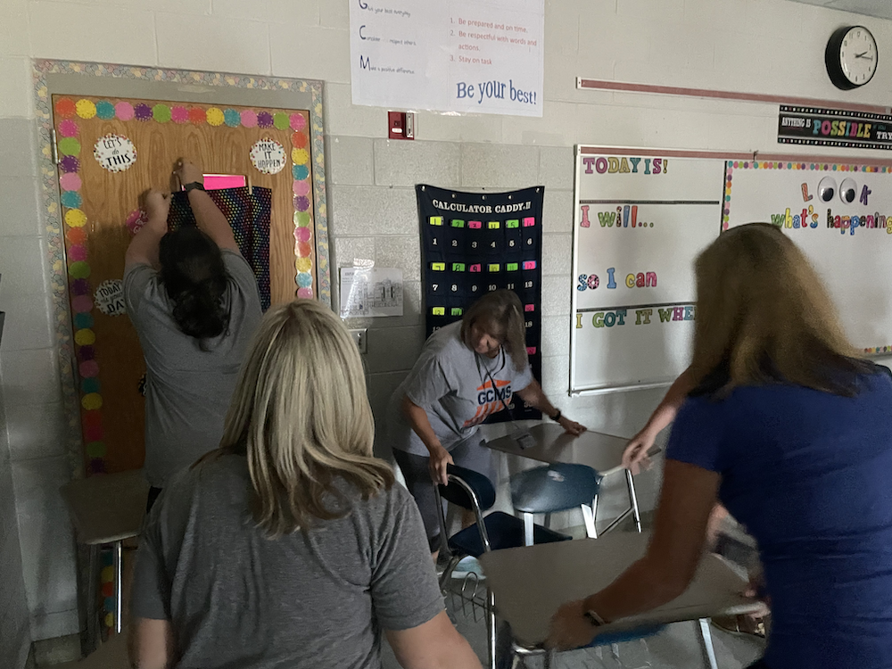 Female teachers shown from back barricadin ga classroom door