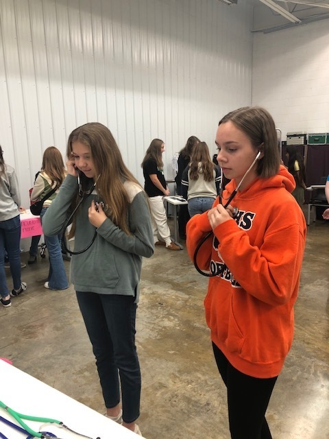 two girls listening through stethoscopes