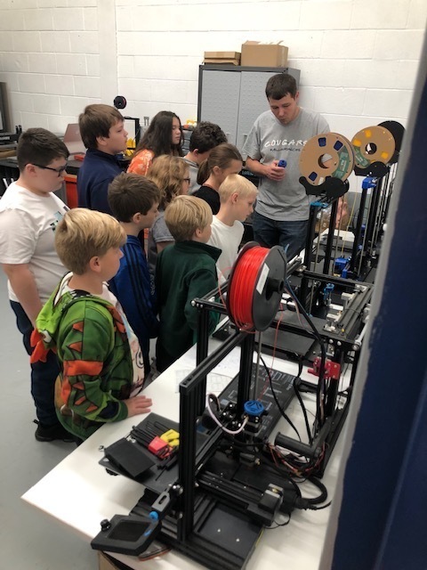 boys and girls looking at 3d printing operation