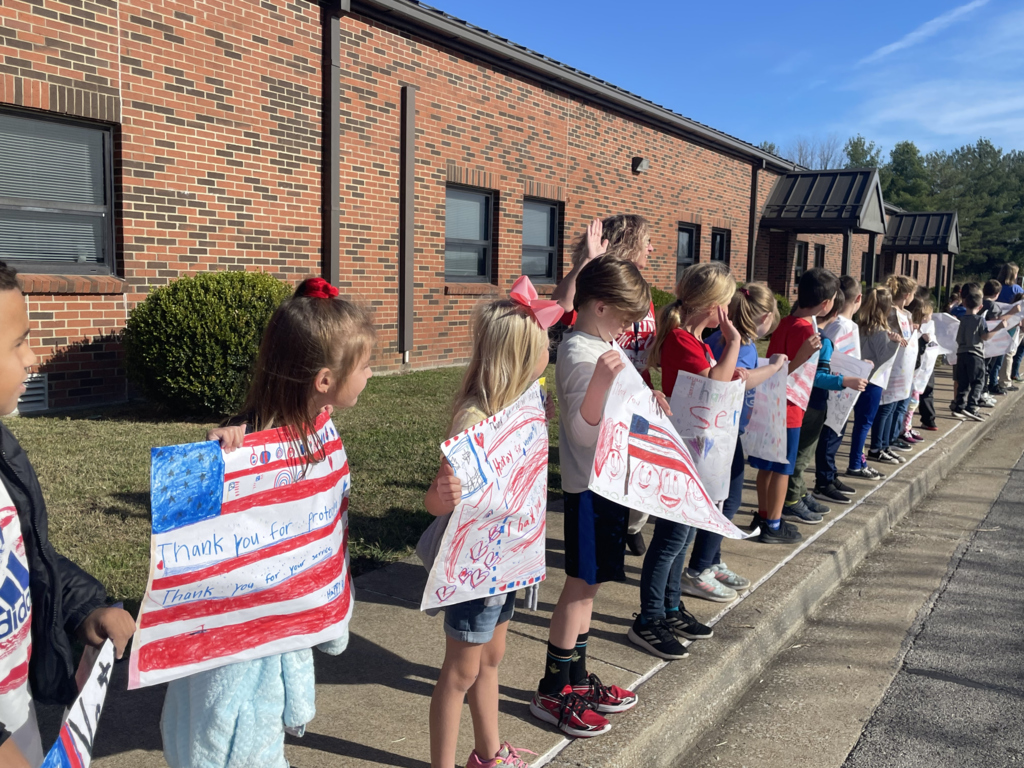 young children holding veterans day signs