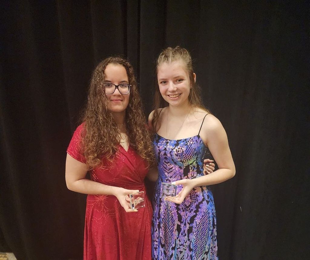 Abby Smith and Sierra Secora standing with arms around each other holding  their Golden Horizon Awards